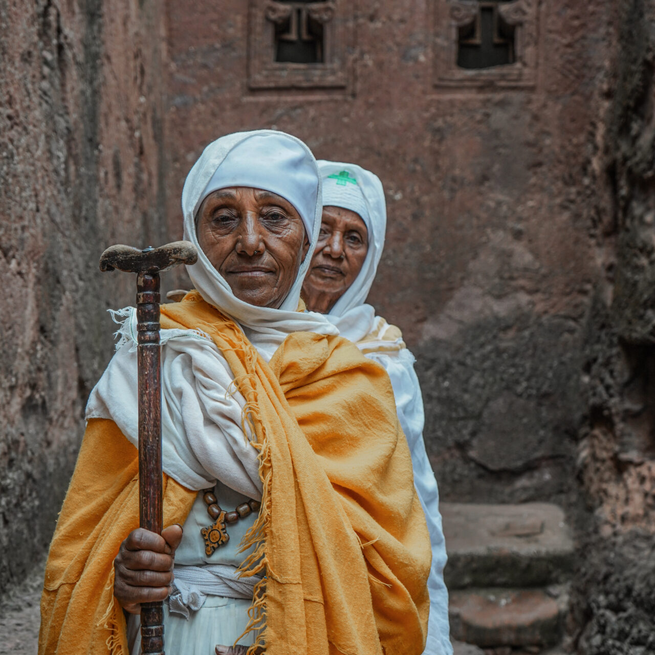 Nuns infront of Bet Michael in Lalibela https://grandholidaysethiopia.com/wp-content/uploads/2018/09/Nuns-infront-of-Bet-Michael-in-Lalibela-1280x1280.jpg